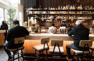 Gäster sitter ensamma vid bardisken i en modern restaurang