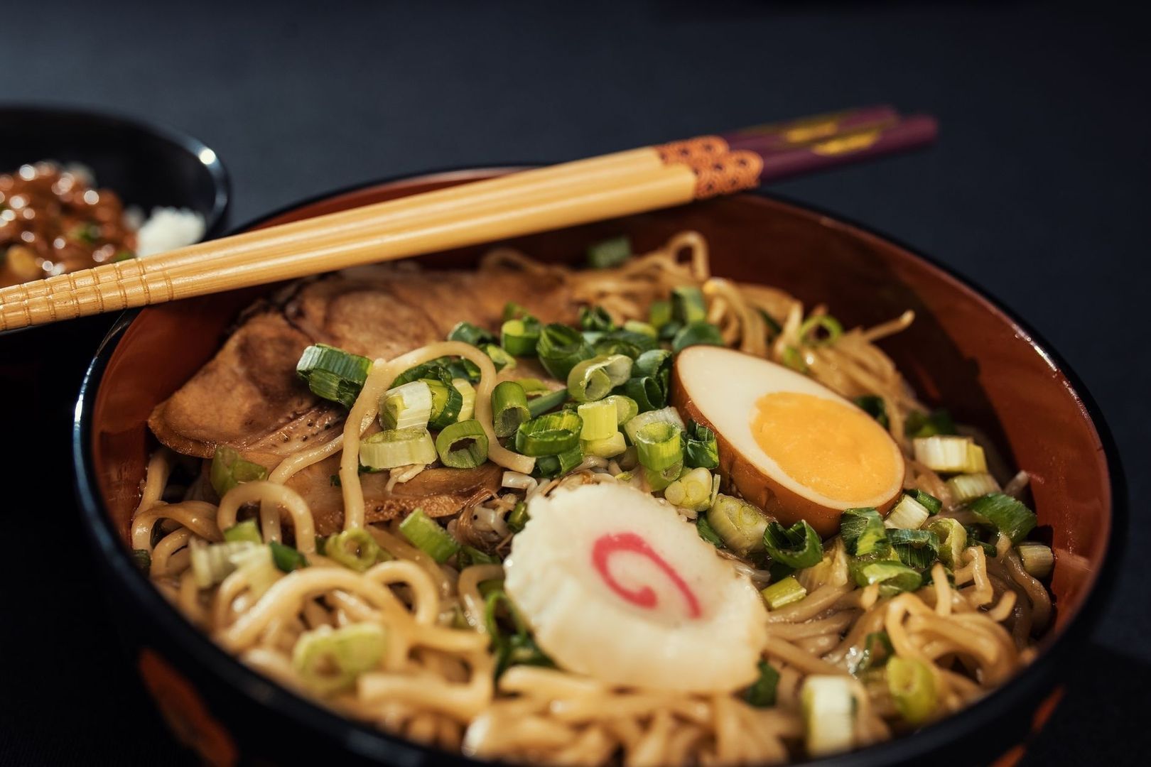 Ramen med nudlar, kött, ägg, salladslök och ätpinnar